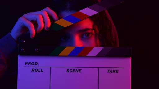 A girl holding a clapperboard